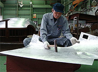 A hammer-wielding craftsman at Yamashita Kogyosho Co. is fashioning a nose for the latest-model Japanese bullet train, the E-6 series, scheduled to go into service in 2013.