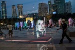 A Shiseido advertisement is reflected in a window in KLCC park outside the Petronas Twin Towers in Kuala Lumpur, Malaysia. (Sanjit Das/Bloomberg)